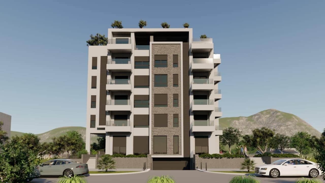 Modern residential complex in Shushan, Montenegro: a multi-story building with terraces, stone cladding, and mountain views.