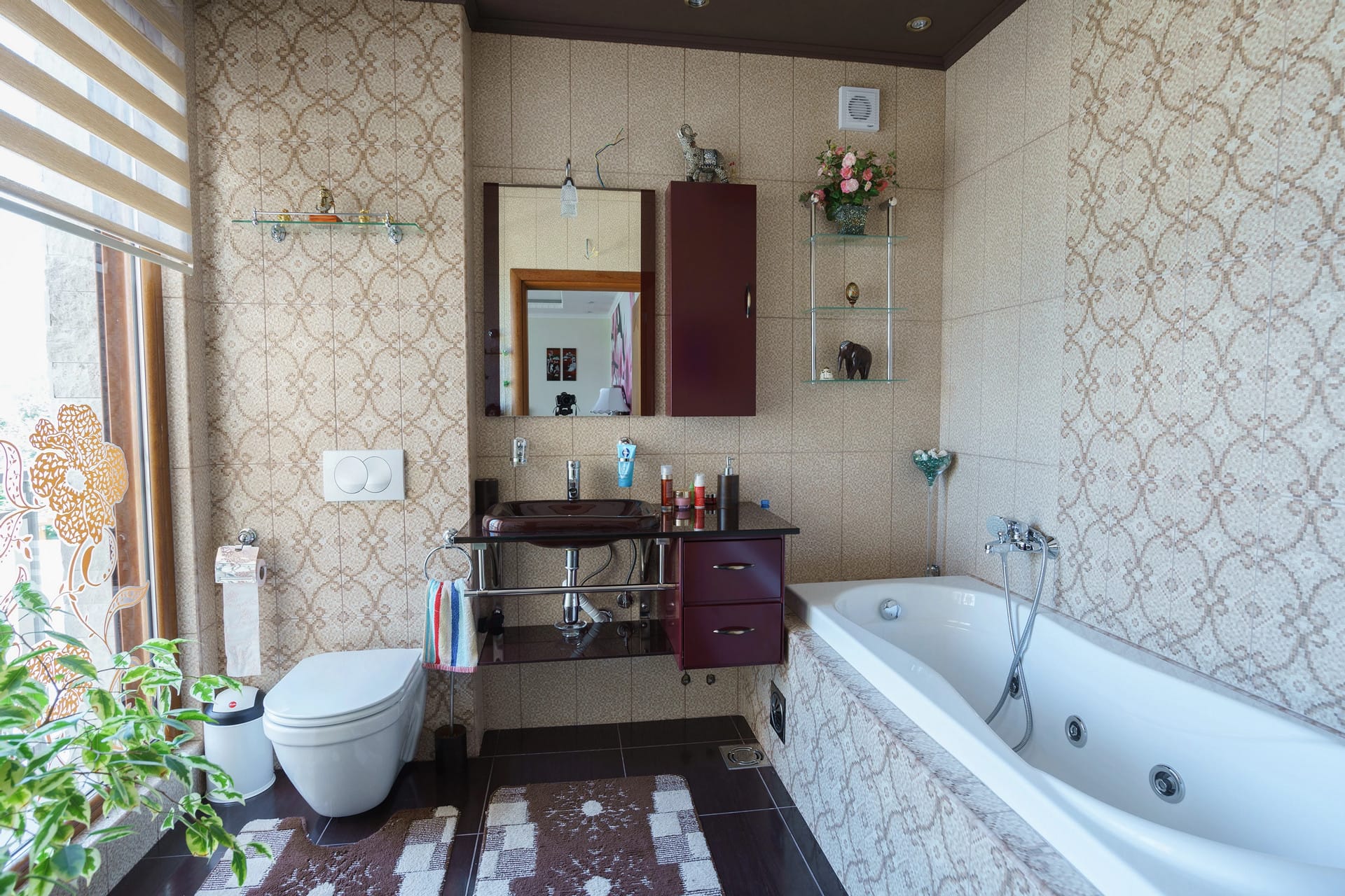 Bathroom in a house in Sutomore, Montenegro: jacuzzi, dark furniture, mirror, and patterned tile in the interior.