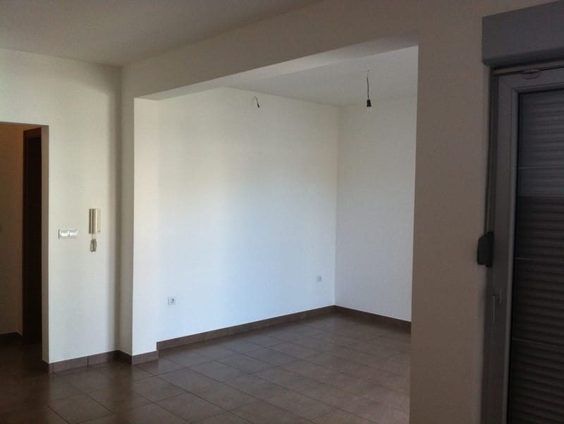 Bright living room with tile in a new apartment in Petrovac, Montenegro: finished interior, access to the balcony, interior view.