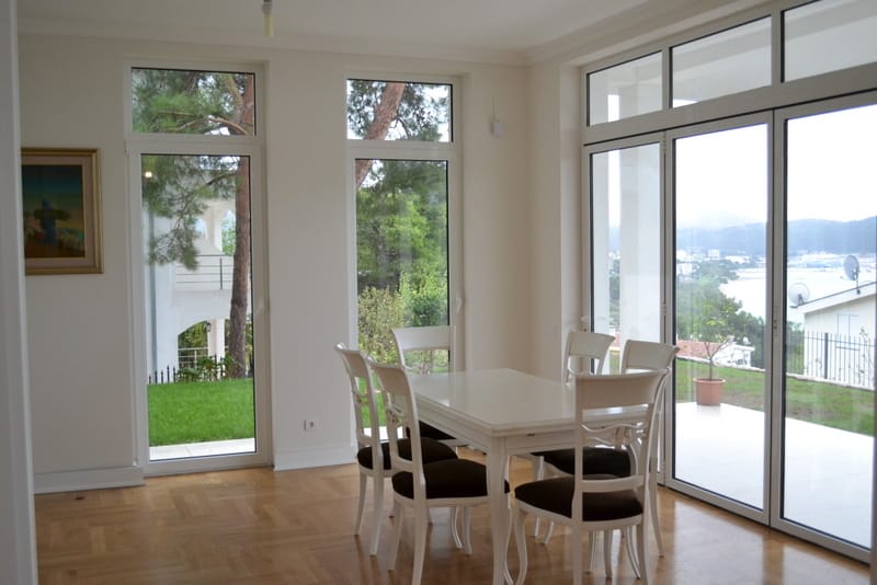Bright living room with dining area and panoramic windows in a house in Shushan, Montenegro, sea and garden view.
