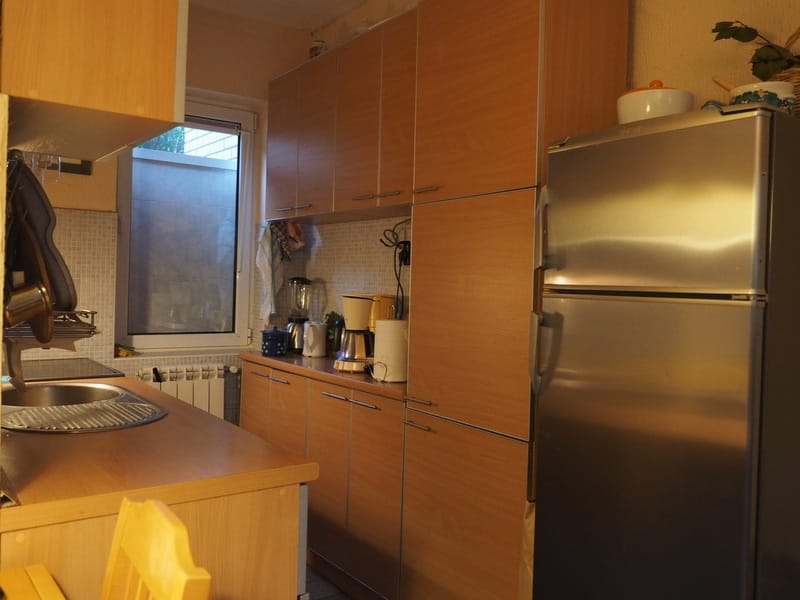 Kitchen with wooden cabinets and a silver refrigerator in a house in Đenovići, Montenegro.