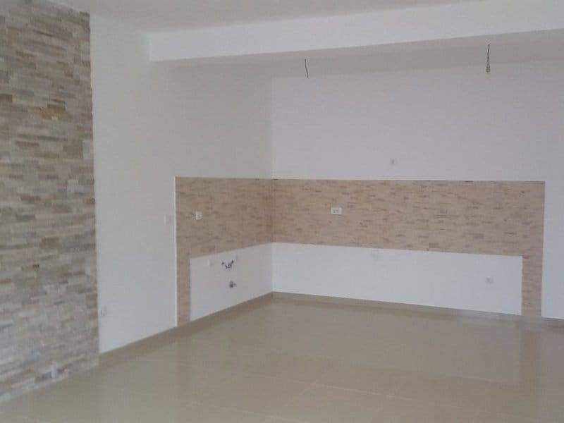 Kitchen in an apartment in Dobrota, Montenegro: light wall finish with decorative stone and tiled floor, space for a kitchen set.