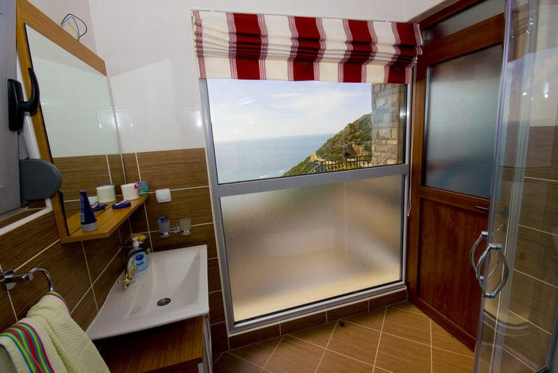 Bathroom with sea view in a house in Dobra Voda, Montenegro: modern finishes, sink, and shower cabin.