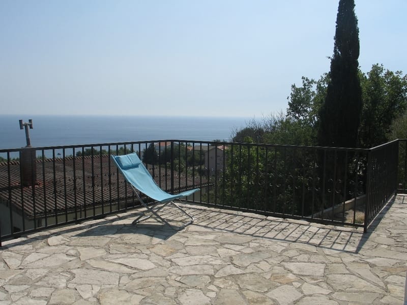 Terrace with sea view in a house, Sutomore, Montenegro: stone floor, wrought-iron railing, and a sun lounger for relaxing.
