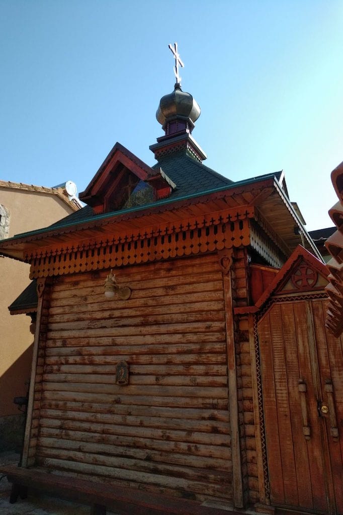 Wooden chapel in Russian style on a plot in Sveti Stefan, Montenegro: view of the log structure with a dome and cross.
