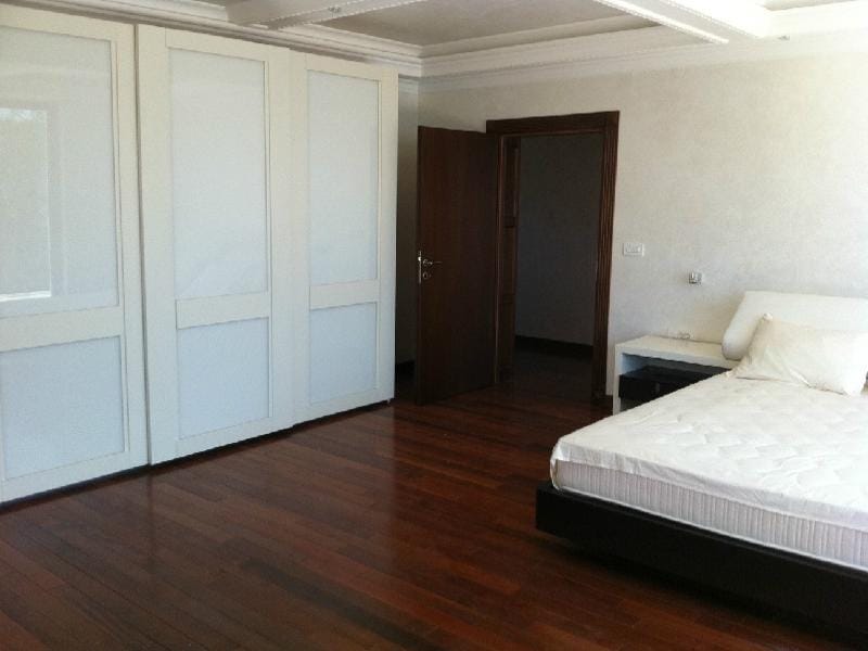 Spacious bedroom in a villa in Herceg Novi, Montenegro: double bed, built-in wardrobe, and parquet flooring.