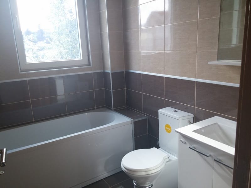 Modern bathroom with tile, bathtub, and plumbing fixtures in a house for sale in Đenovići, Montenegro.