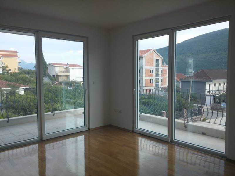 Bright living room with panoramic windows, a terrace, and mountain views in a house, Đenovići, Montenegro.