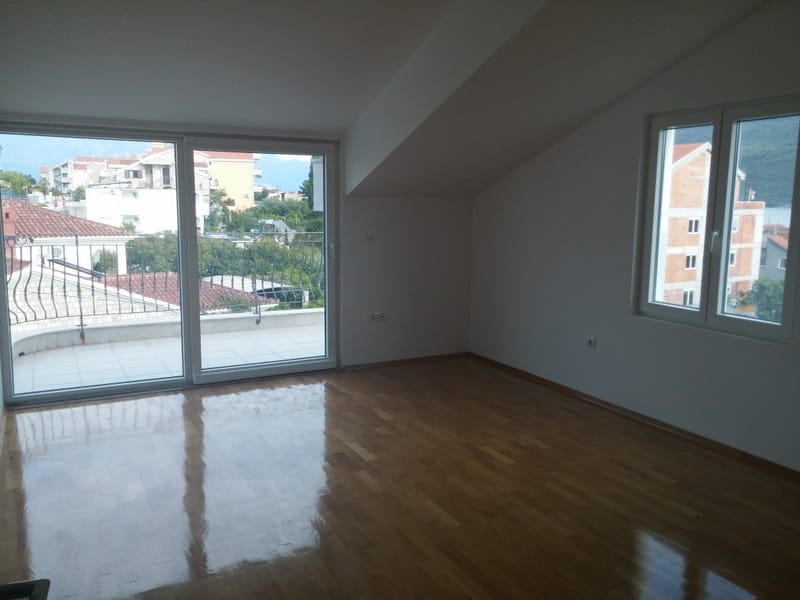 Bright living room with parquet flooring and access to the terrace in a house, Đenovići, Montenegro. City and mountain view.