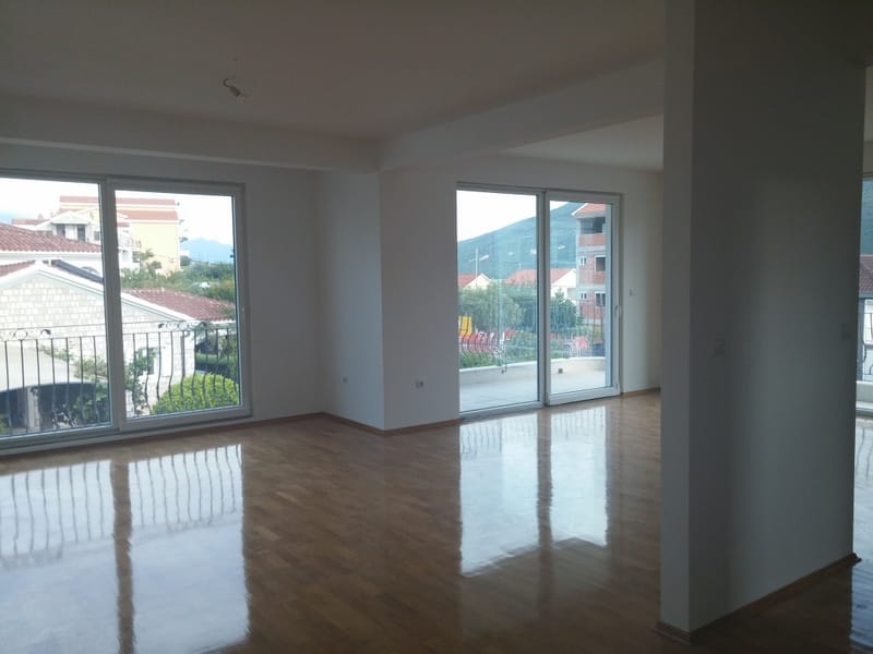Spacious living room with parquet flooring and panoramic windows in a house, Đenovići, Montenegro.