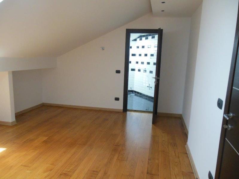 Bright attic bedroom with parquet flooring in an apartment, Rafailovici, Montenegro, view of the bathroom with tile.