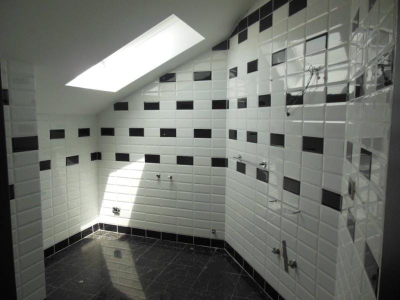 Bathroom with black-and-white tiles and a skylight in an apartment, Rafailovici, Montenegro.