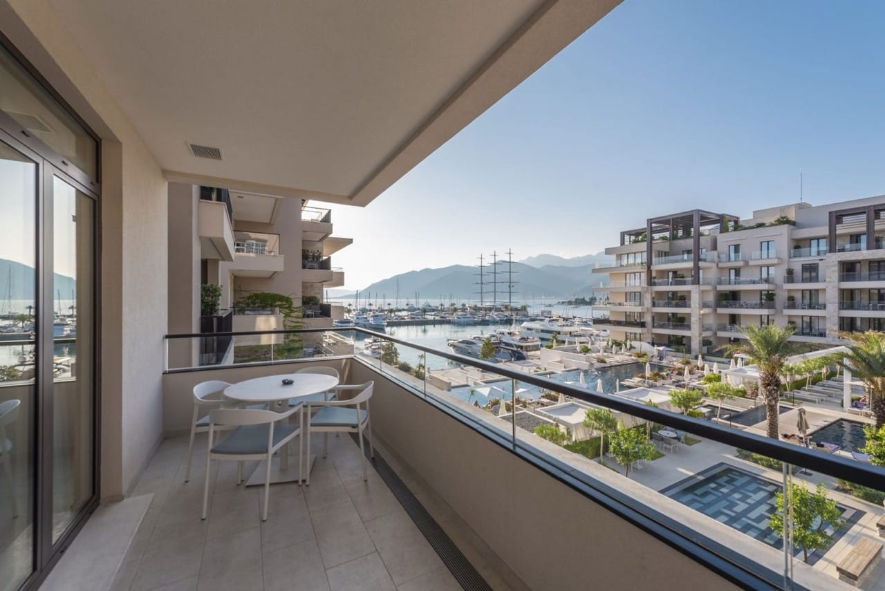 Balcony with furniture and views of the yacht marina and pool in the luxury Porto Montenegro complex, Tivat, Montenegro.