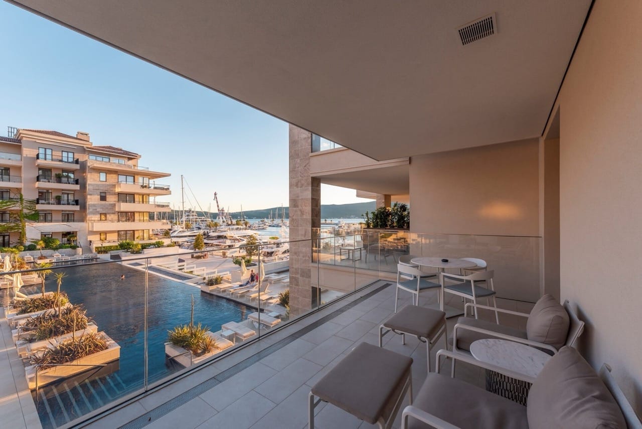 Balcony with furniture and views of the marina and pool in the luxury Porto Montenegro residential complex, Tivat, Montenegro.
