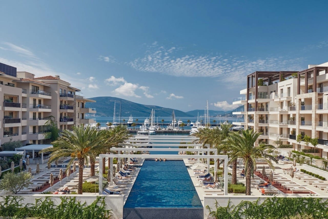 Pool and luxury apartments in Porto Montenegro, Tivat, Montenegro: marina view with yachts and mountains.