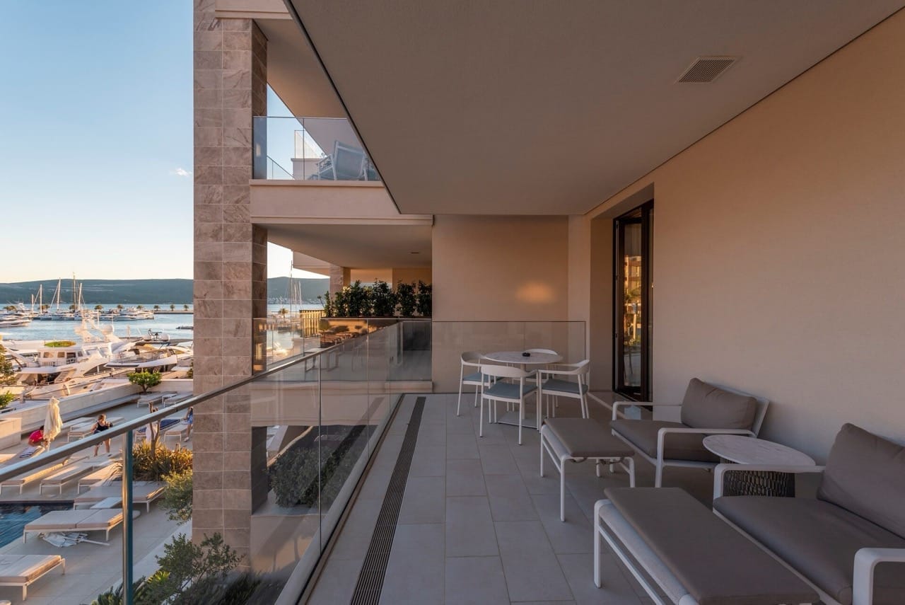 Spacious terrace with furniture in the premium Porto Montenegro residential complex, Tivat, Montenegro, overlooking the yacht marina and pool.