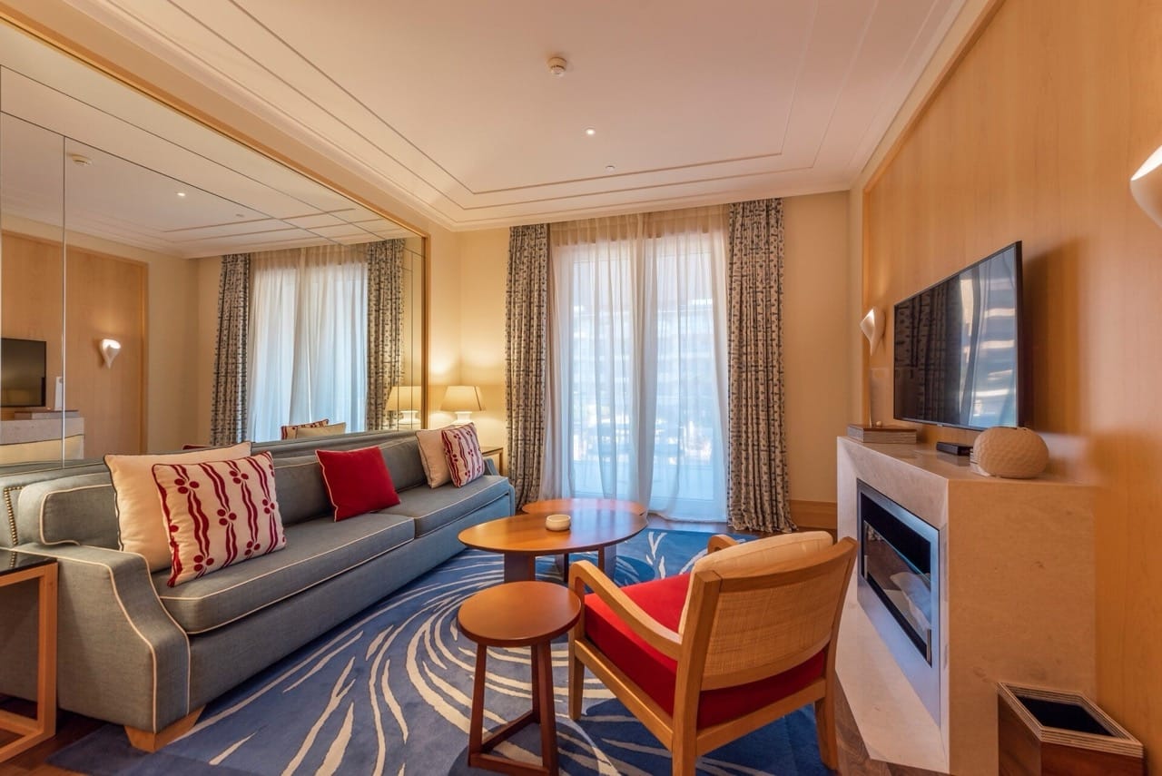 Cozy living room with a fireplace and a blue sofa in an apartment in Porto Montenegro, Tivat, Montenegro. Modern interior.