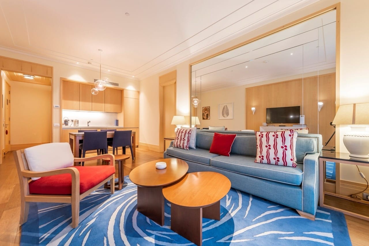 Living room with modern furniture and kitchen in Porto Montenegro apartments, Tivat, Montenegro. Light-toned interior.