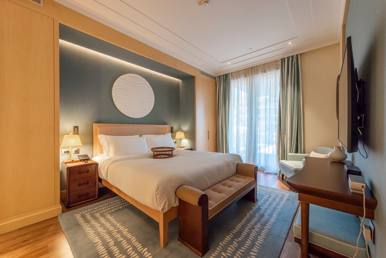 Modern bedroom in Porto Montenegro apartments, Tivat, Montenegro: double bed, decor, and view of the terrace.