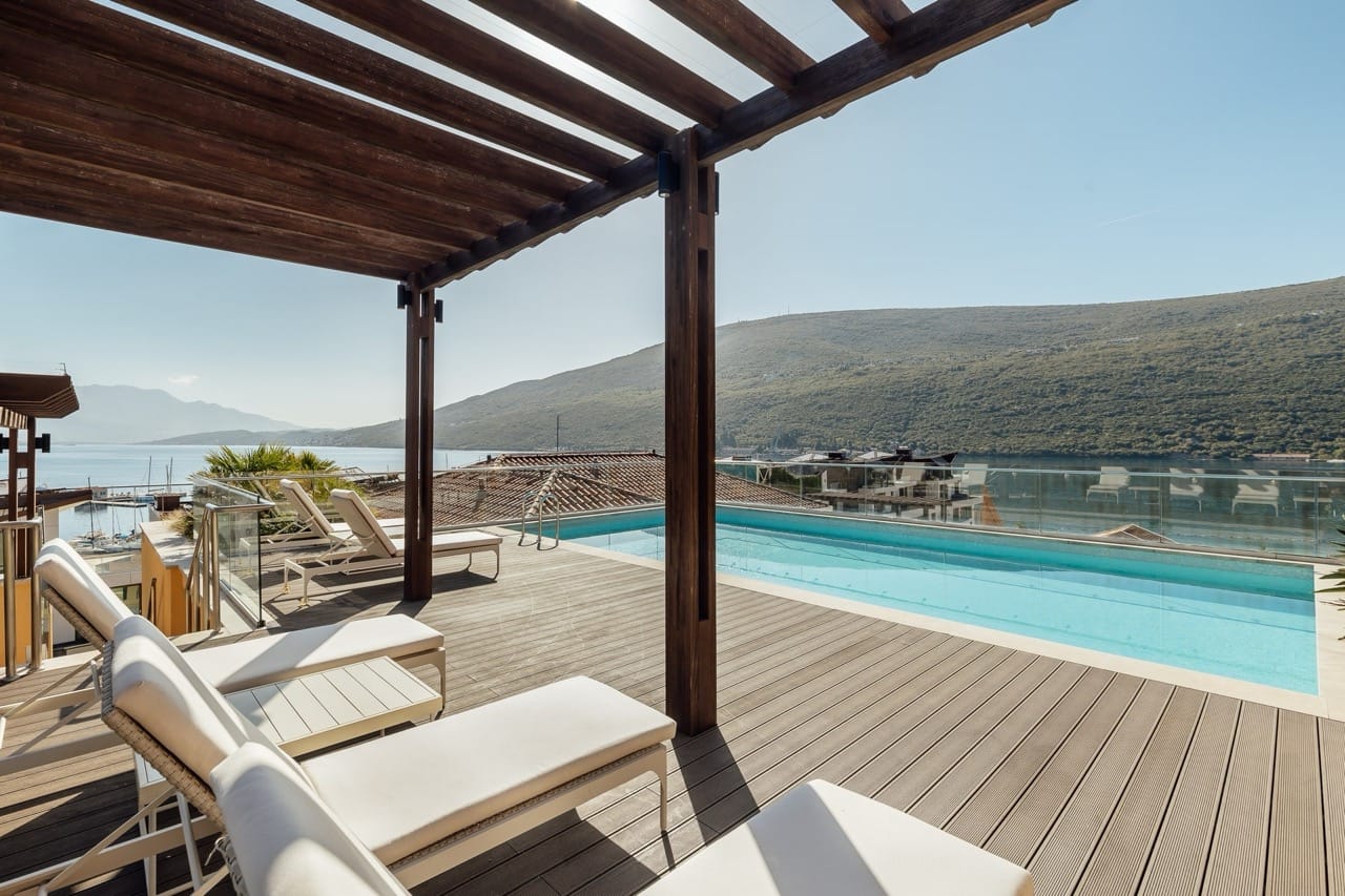 Terrace with a pool and sun loungers in Portonovi, Kumbor, Montenegro, with panoramic sea and mountain views.