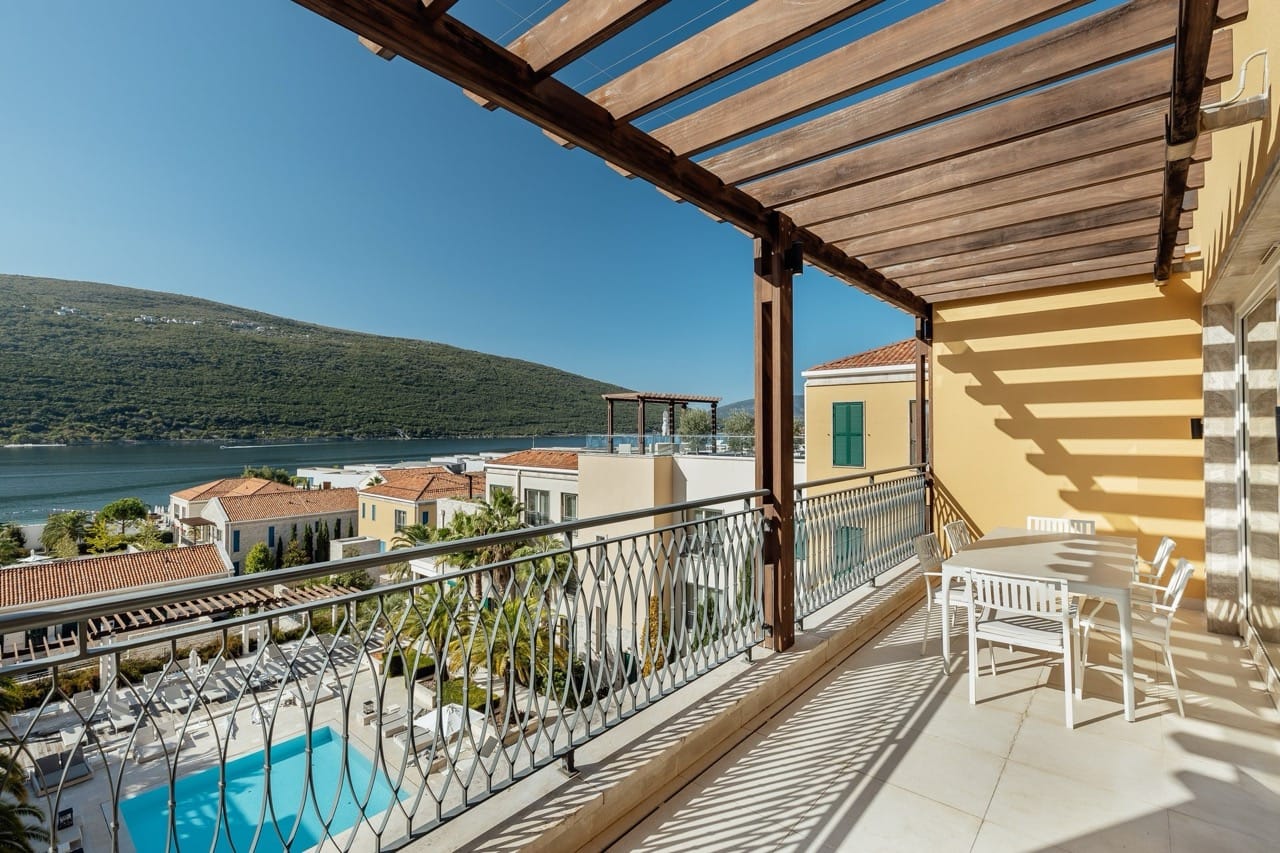 Terrace with dining area and sea and pool views in the Portonovi residential complex, Kumbor, Montenegro.