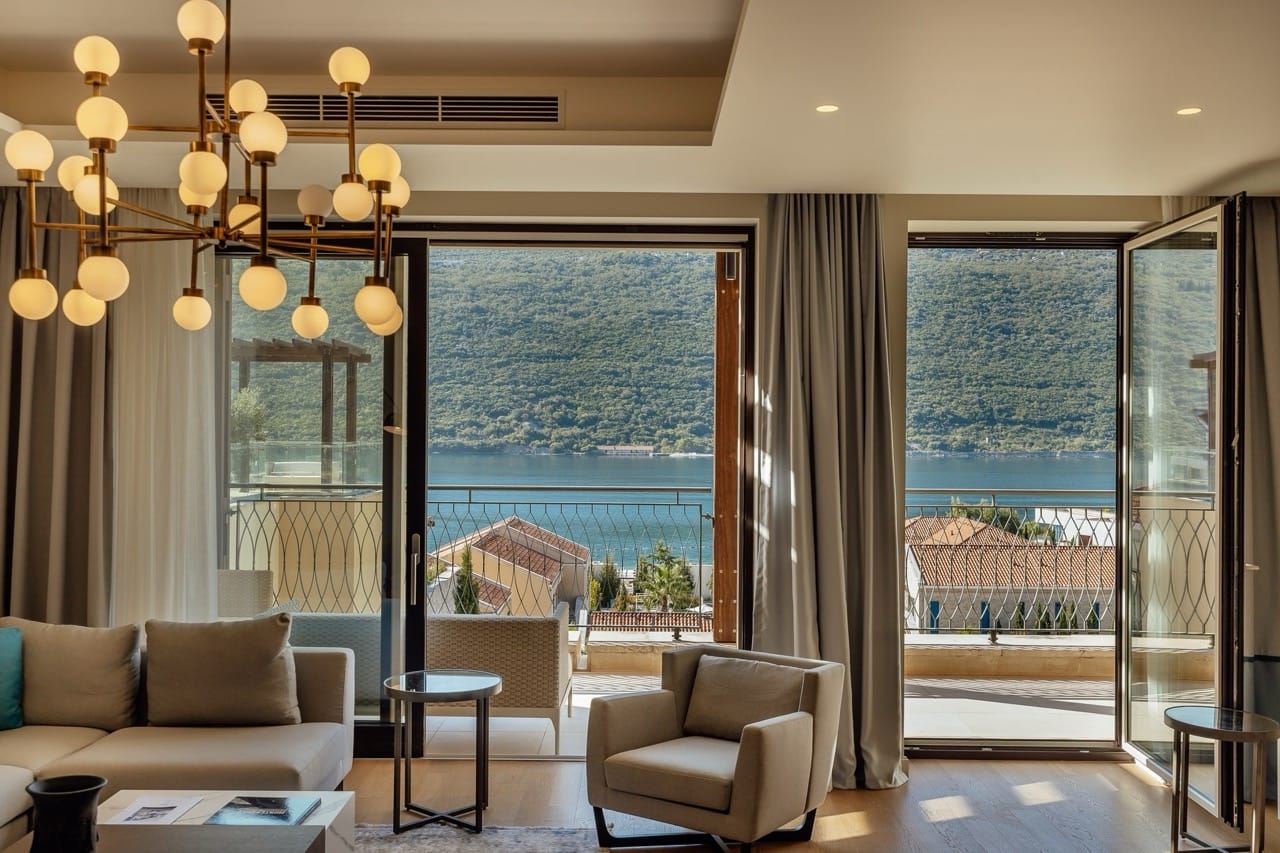Living room in an apartment in Portonovi, Kumbor, Montenegro: modern furniture, a designer chandelier, and a view of the Bay of Kotor.
