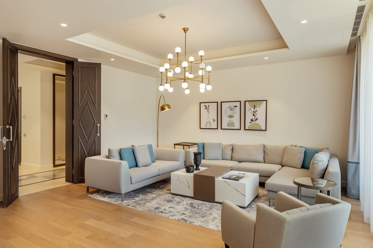 Modern living room in an apartment in Portonovi, Kumbor, Montenegro: light furniture, a marble coffee table, and a designer chandelier.