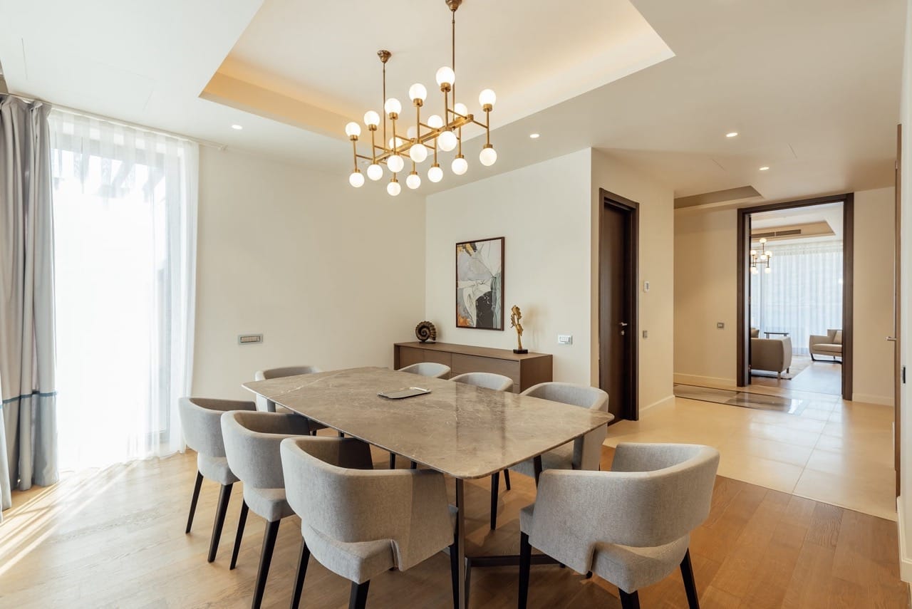 Modern dining area with a marble table in an apartment in Portonovi, Kumbor, Montenegro. Designer chandelier and decor.