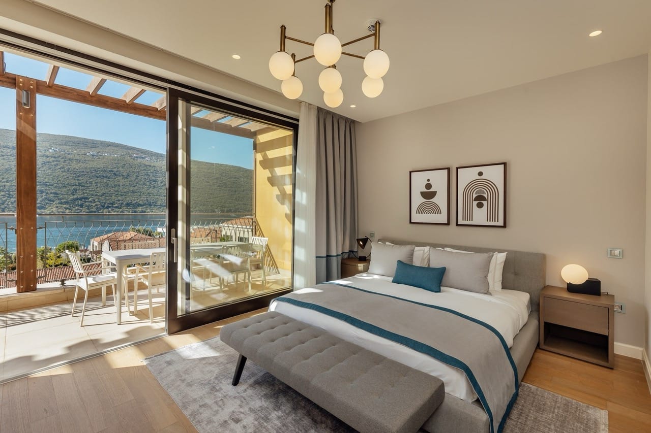 Modern bedroom in Portonovi, Kumbor, Montenegro: double bed, terrace with sea and mountain views.