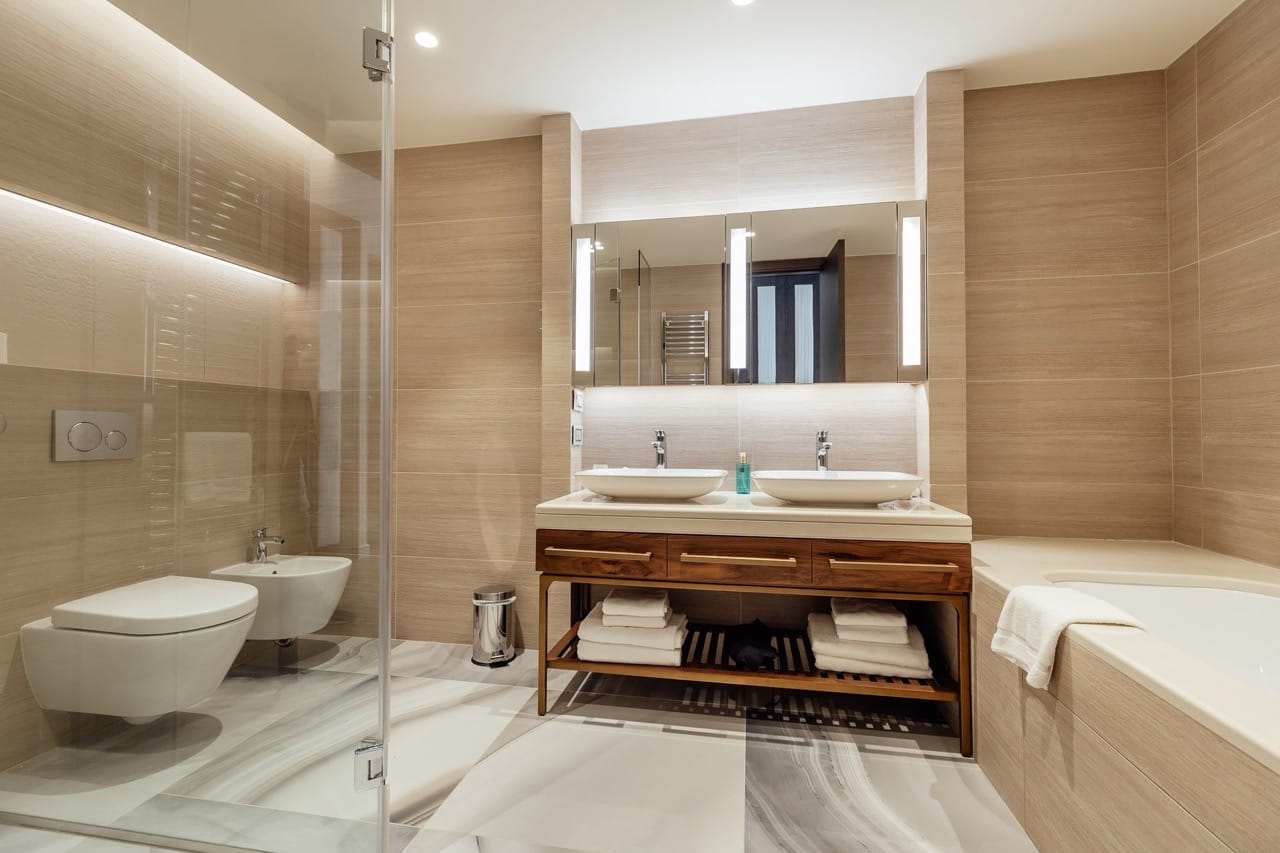 Modern bathroom in an apartment in Portonovi, Kumbor, Montenegro: two sinks, shower, and wood-style finishes.