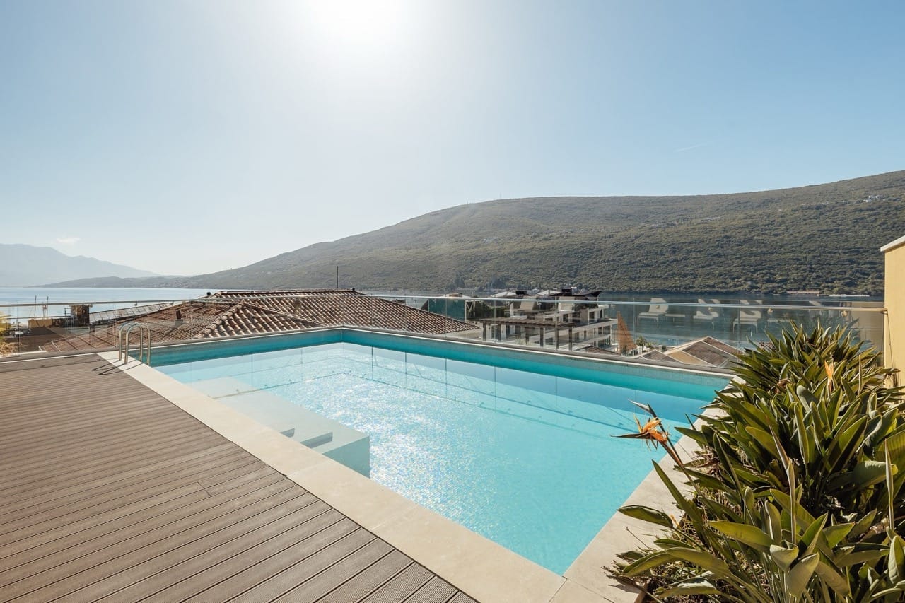 Outdoor pool on the terrace with sea and mountain views in the Portonovi residential complex, Kumbor, Montenegro.