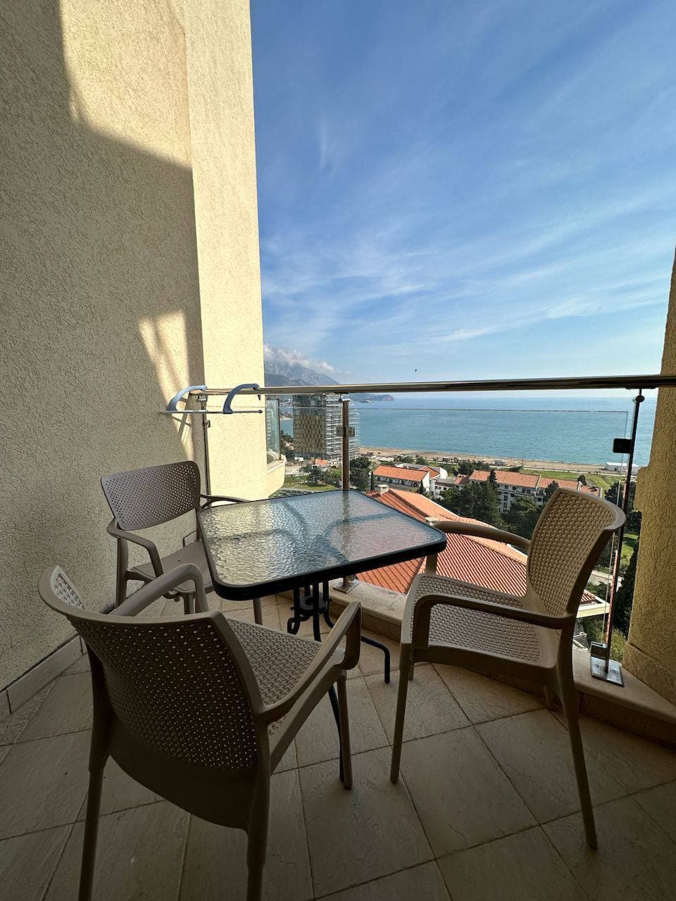 Терраса с мебелью и панорамным видом на море и пляж в апартаментах Бечичи, Черногория.