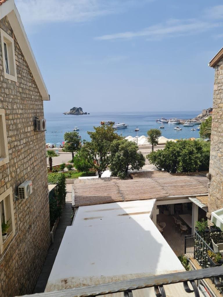Вид на море и пляж Петровац из апартаментов в Черногории, каменная отделка фасада, терраса с видом на острова.