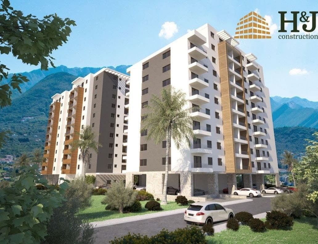 Современный жилой комплекс с балконами и парковкой в городе Бар, Черногория, на фоне горных пейзажей.