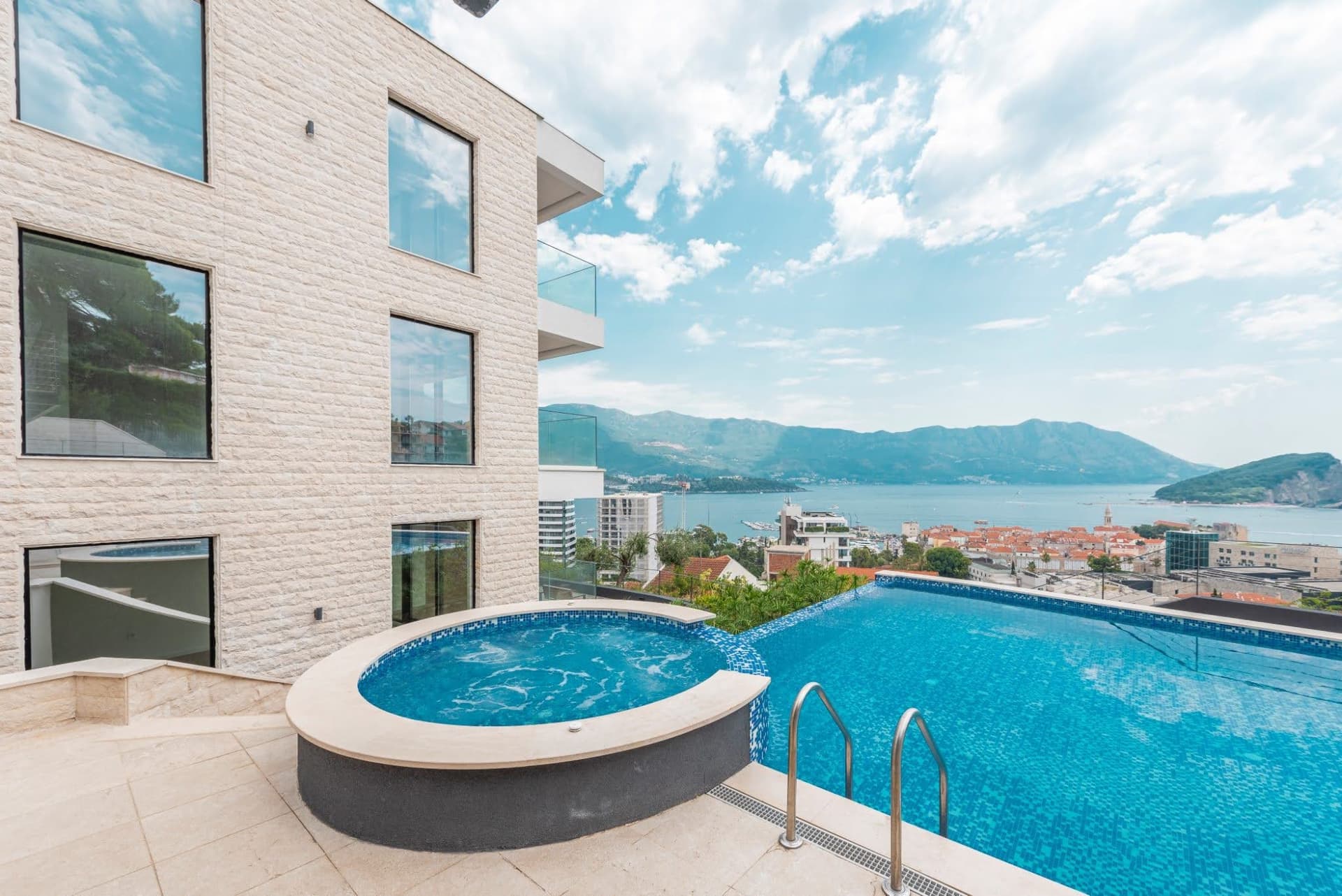 Бассейн с джакузи и панорамным видом на море и город Будва, Черногория в современном жилом комплексе.