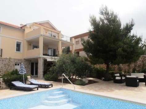 Вилла в Луштице, Черногория: бассейн, терраса с шезлонгами, зона отдыха с мягкой мебелью и ухоженный сад с деревьями.