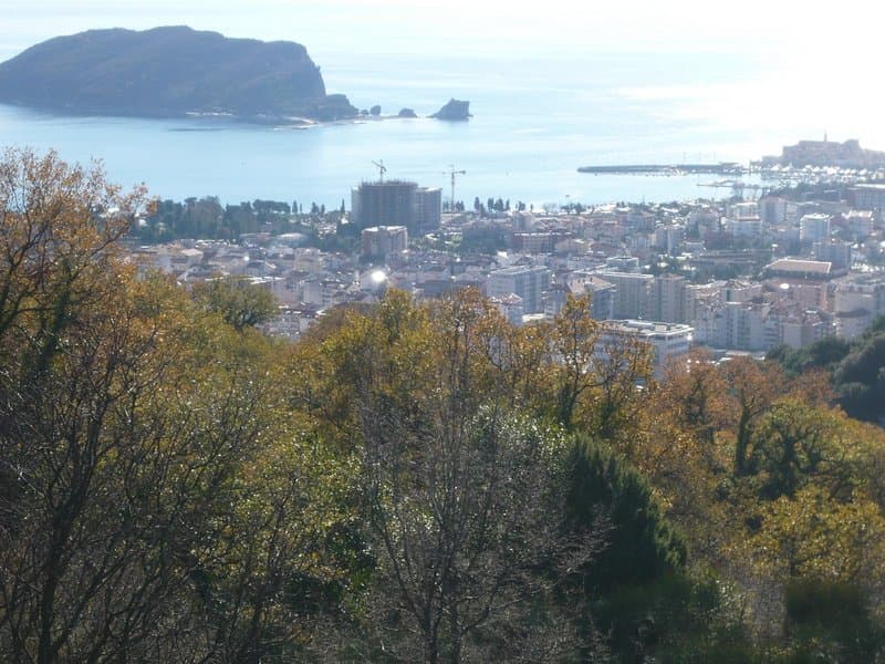 Панорамный вид на город Будва и остров Святого Николая из земельного участка в Черногории, вид на море и горы.