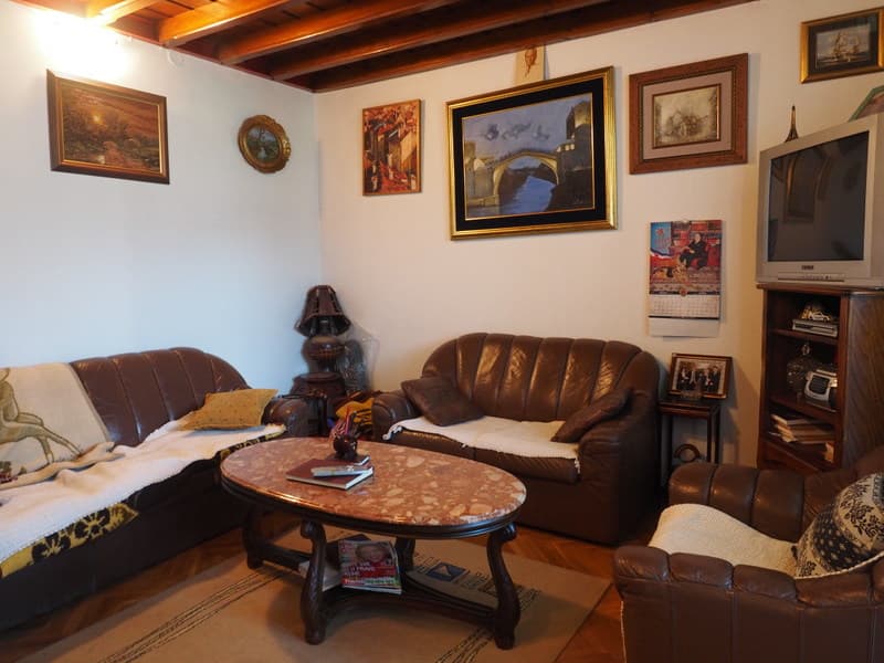 Гостиная с кожаной мебелью и деревянным потолком в квартире на продажу в городе Бар, Черногория.