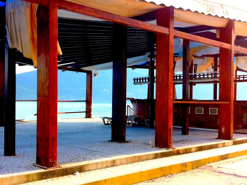 Терраса ресторана с деревянными опорами и видом на море в Герцег-Нови, Черногория.