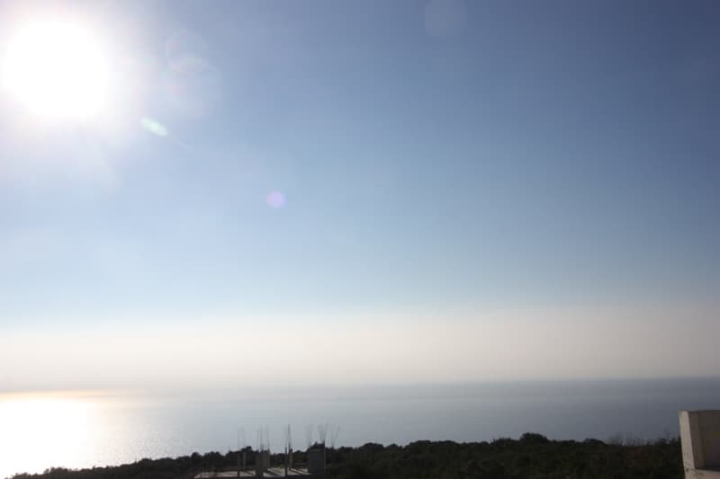 Панорамный вид на море с земельного участка в Крымовице, Черногория: солнечный горизонт и природный ландшафт.