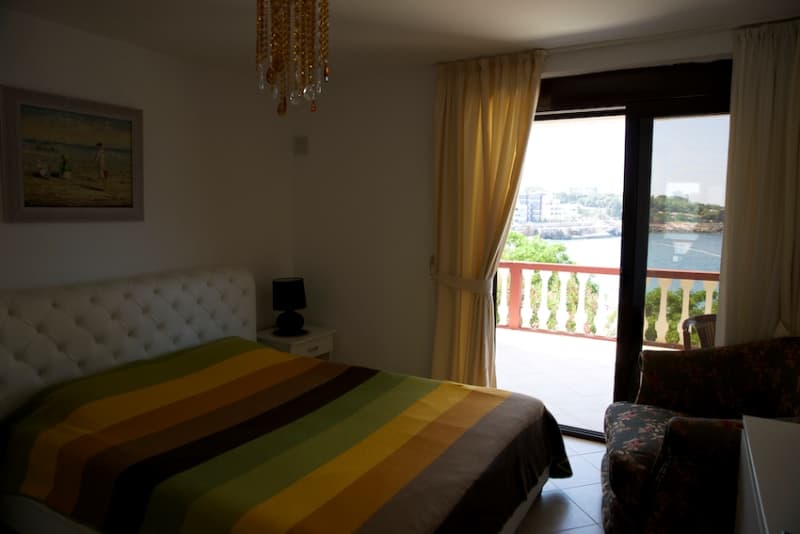 Спальня в доме в Добрых Водах, Черногория: двуспальная кровать, выход на террасу с панорамным видом на море.