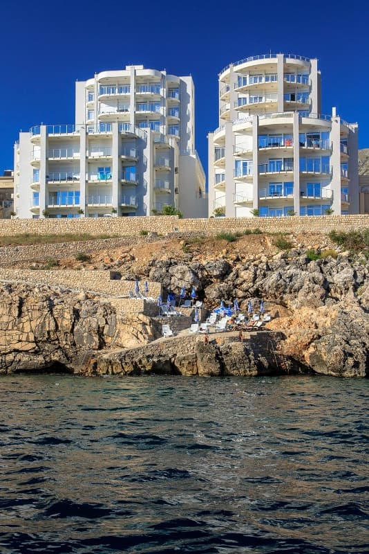 Современные апартаменты в Добрых Водах, Черногория: вид на жилой комплекс у моря с собственным пляжем и шезлонгами.