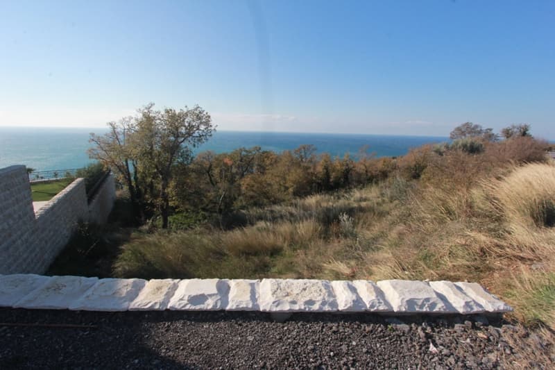 Земельный участок в Режевичи, Черногория с панорамным видом на Адриатическое море и каменной оградой на территории.