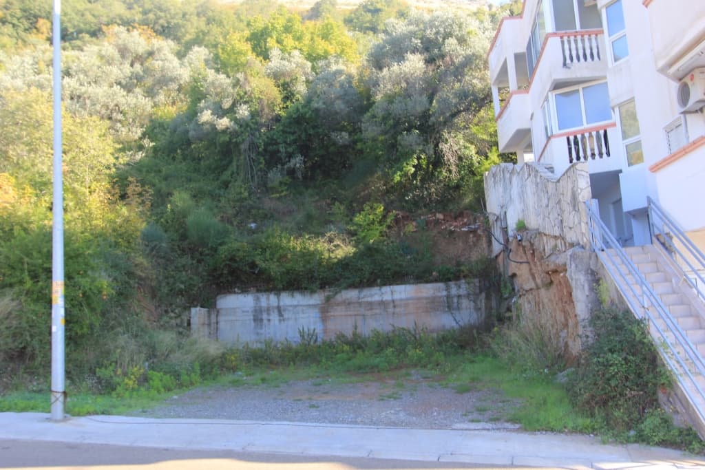 Земельный участок под застройку в Петроваце, Черногория: ровная площадка у подножия холма рядом с жилым домом.