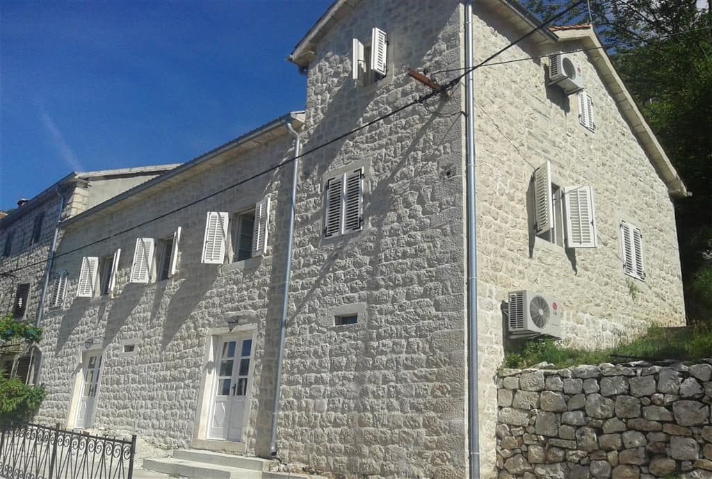 Двухэтажная каменная вилла в средиземноморском стиле в Дражин Врт, Черногория: фасад из натурального камня и ставни.