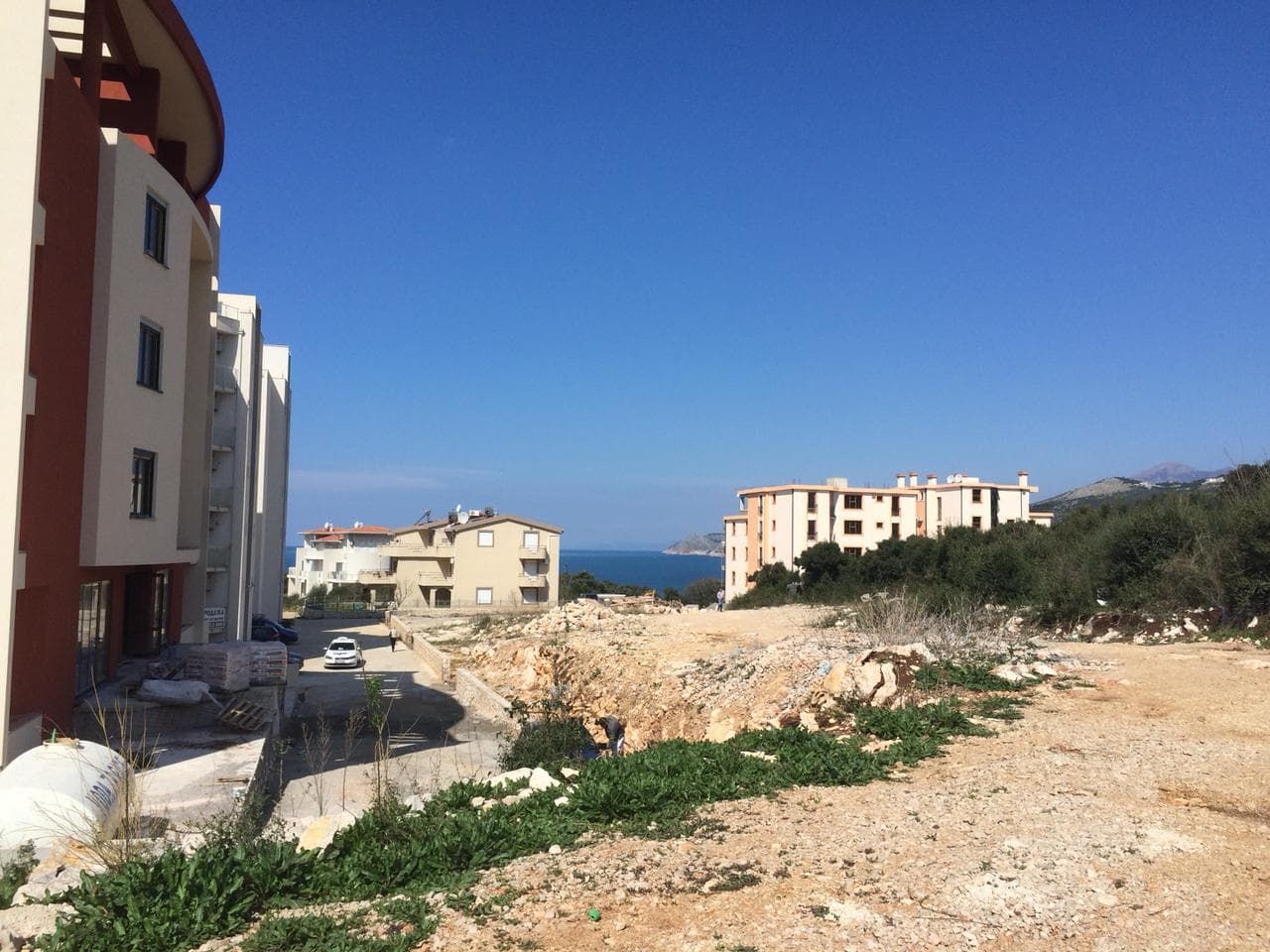 Земельный участок под застройку с видом на море в Добрых Водах, Черногория: рядом современные жилые дома и инфраструктура.