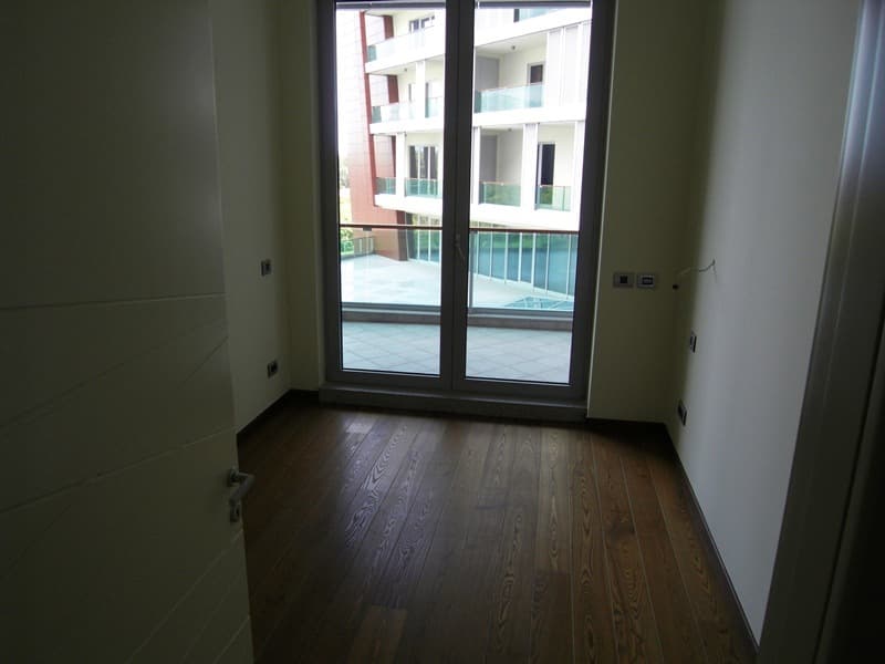 Светлая комната с паркетом и выходом на террасу в современной квартире в Будве, Черногория.