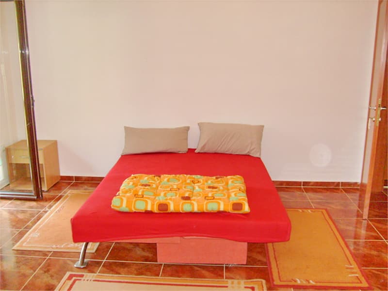 Спальня с двуспальной кроватью и кафельным полом на вилле в Прчани, Черногория. Уютный интерьер для аренды жилья.