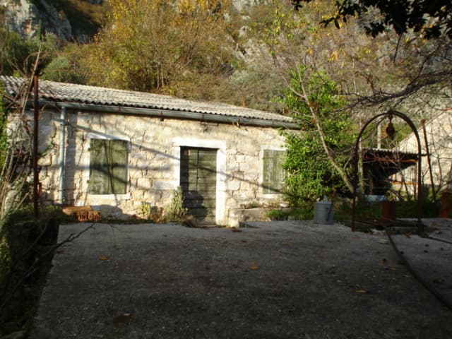 Старинный каменный дом под реконструкцию на земельном участке в Герцег-Нови, Черногория, с колодцем во дворе.