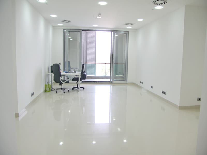 Светлый офисный кабинет с белой отделкой и выходом на балкон в бизнес-центре Будвы, Черногория.